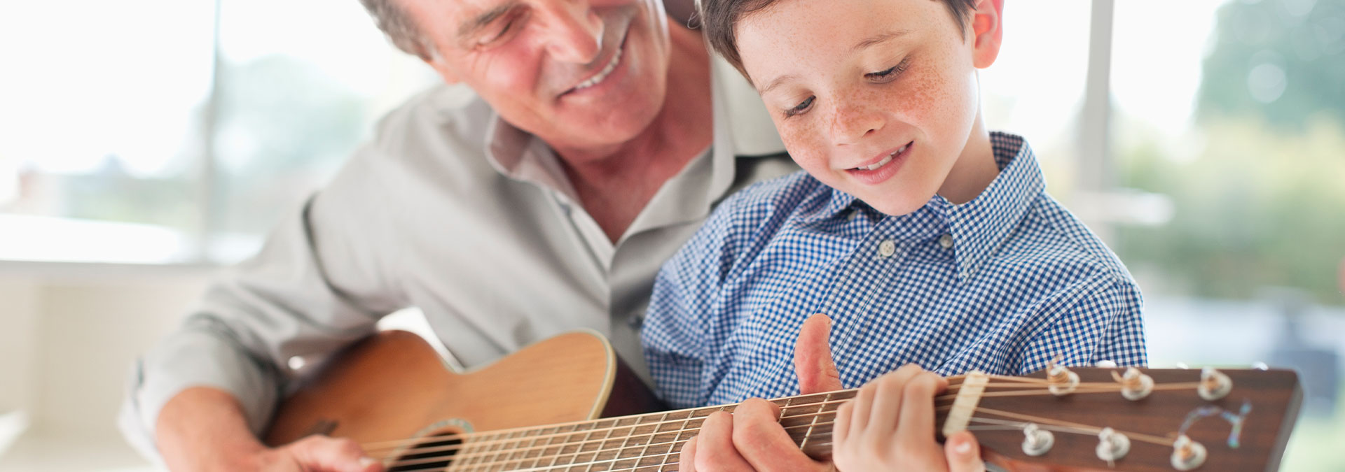 Grandfather and grandson playing the guitar
